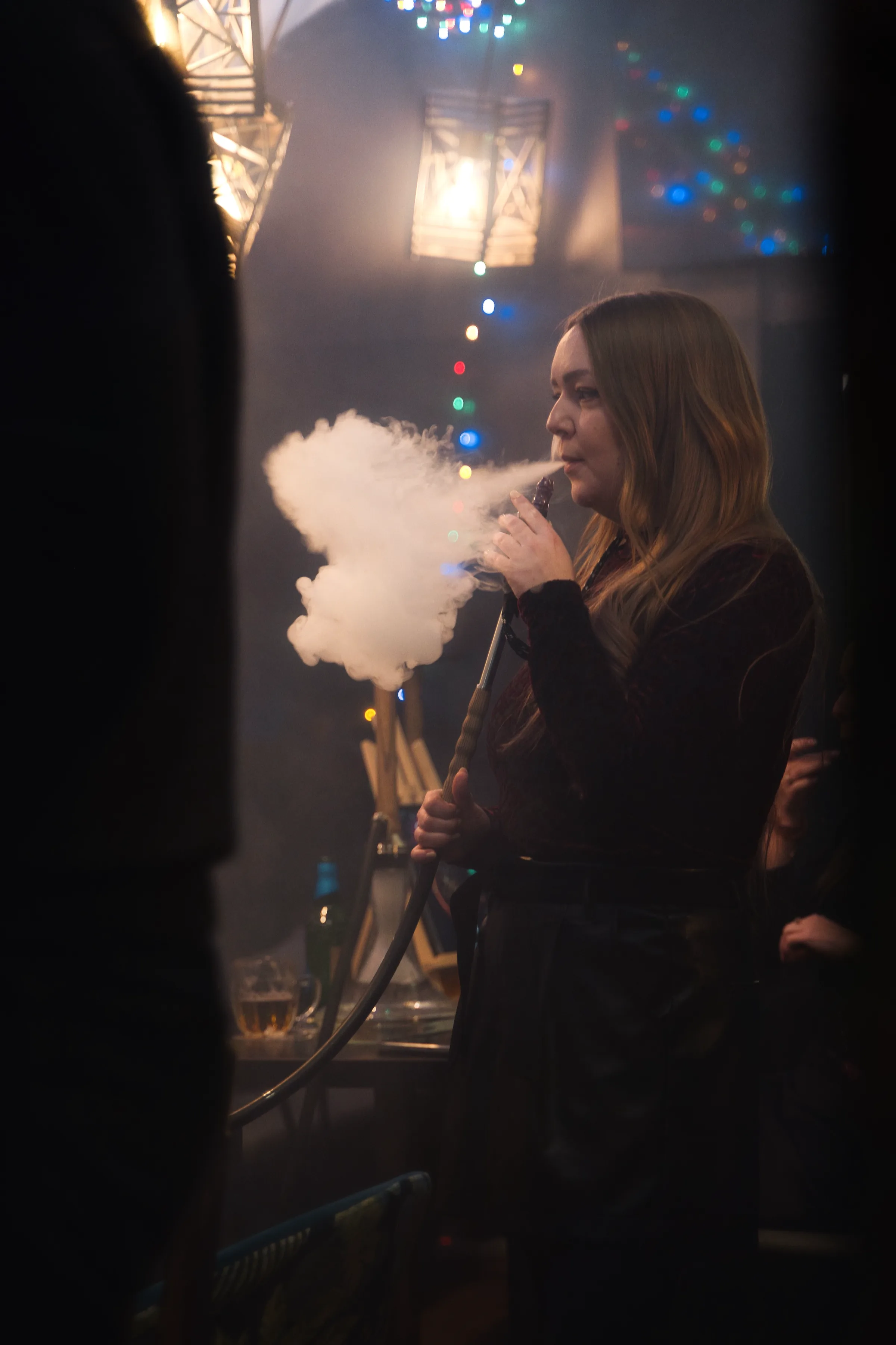 A guest exhaling a cloud of hookah smoke