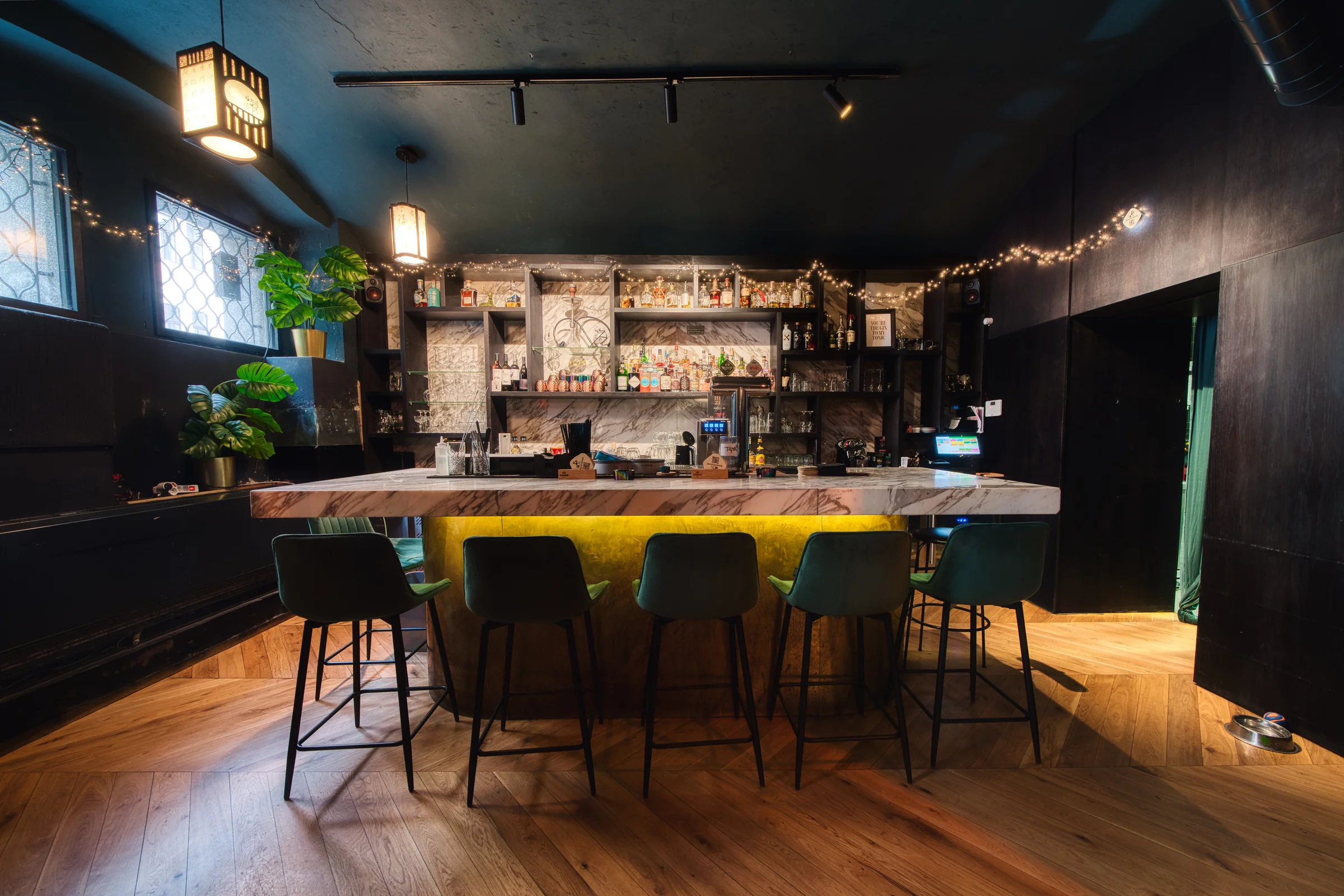 Bar stools along the lit marble counter