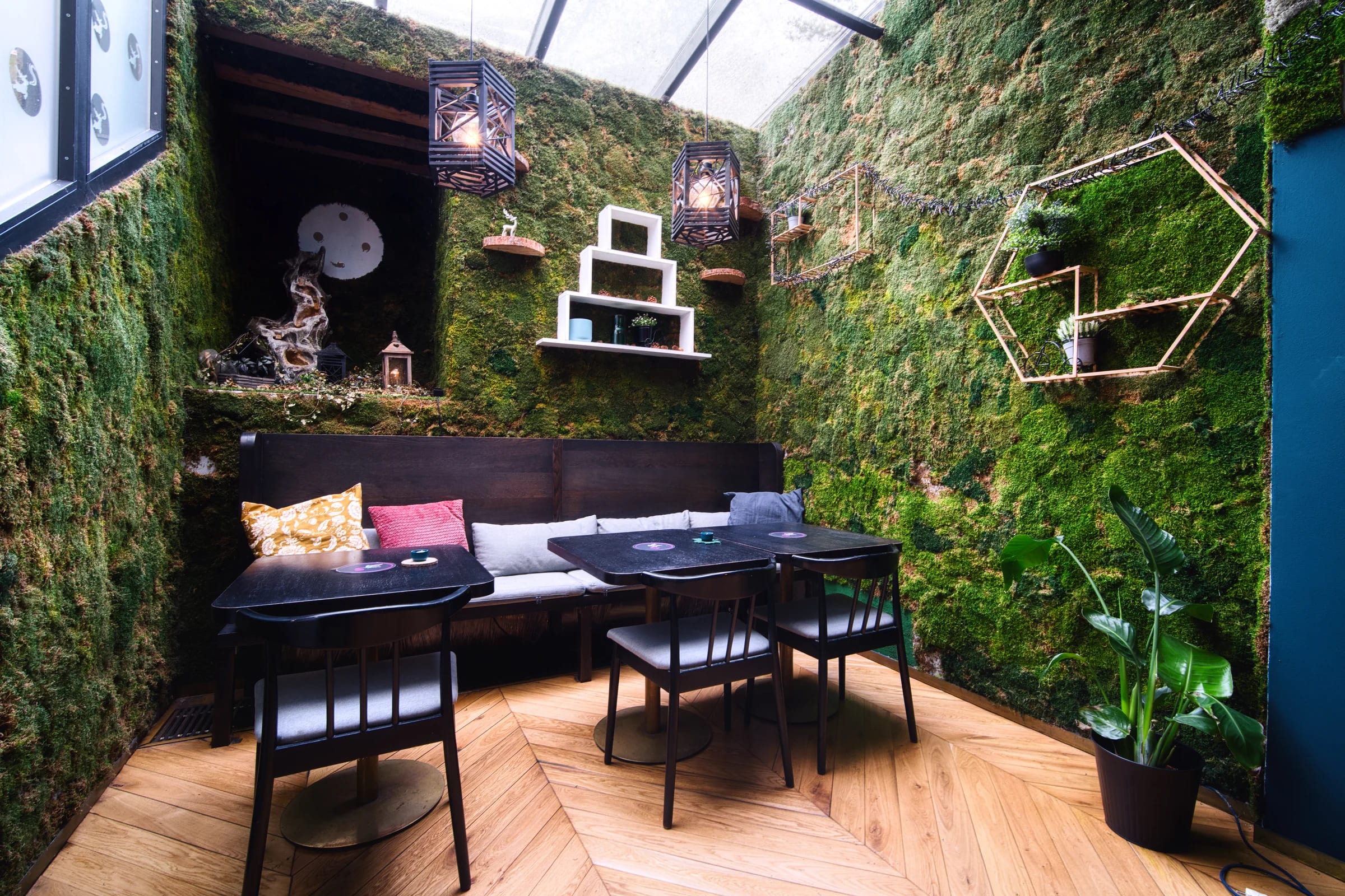 Moss-walled lounge with hanging lamps
